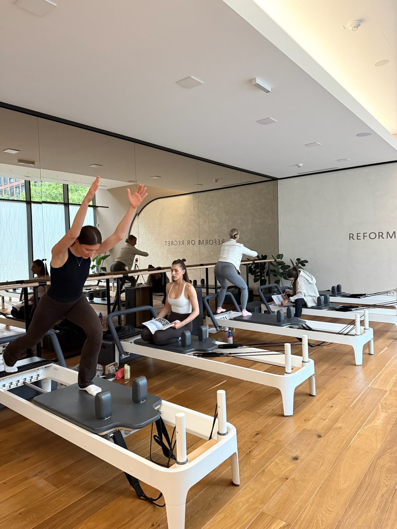 Instructor coaching a student on Pilates studio equipment at a Body Form Education intake
