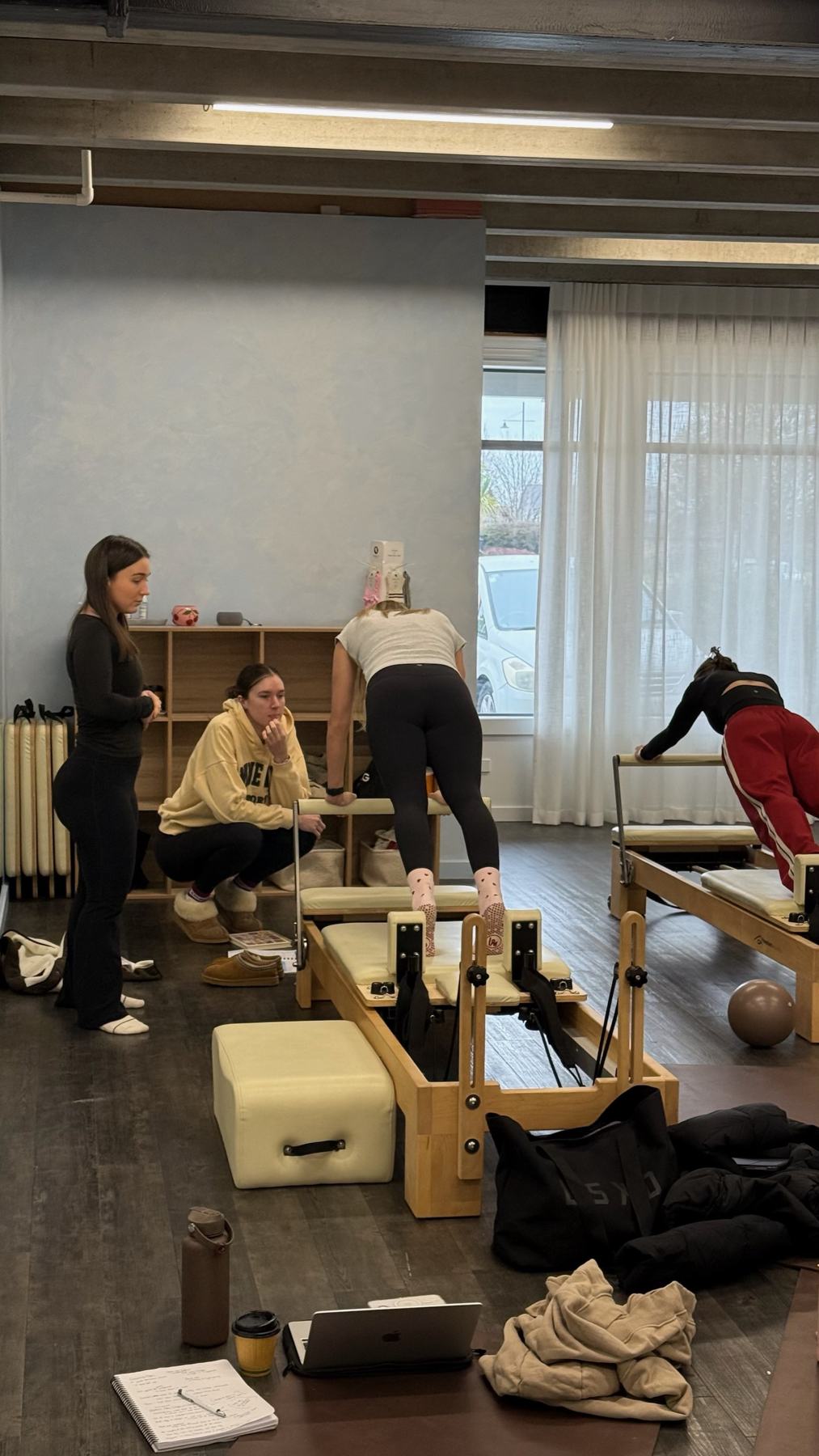 Instructor coaching a student on Pilates studio equipment at a Body Form Education intake