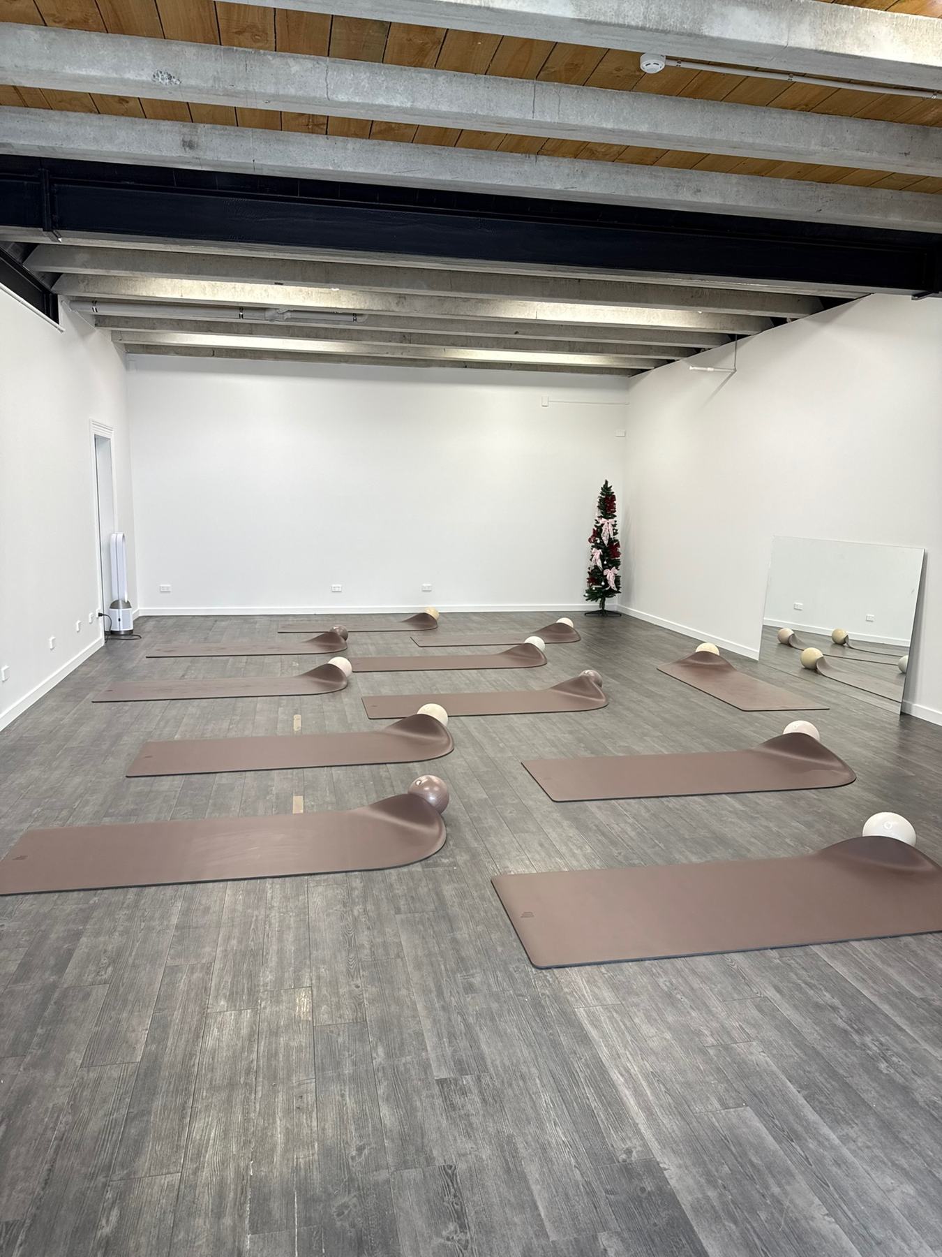 Instructor coaching a student on Pilates studio equipment at a Body Form Education intake