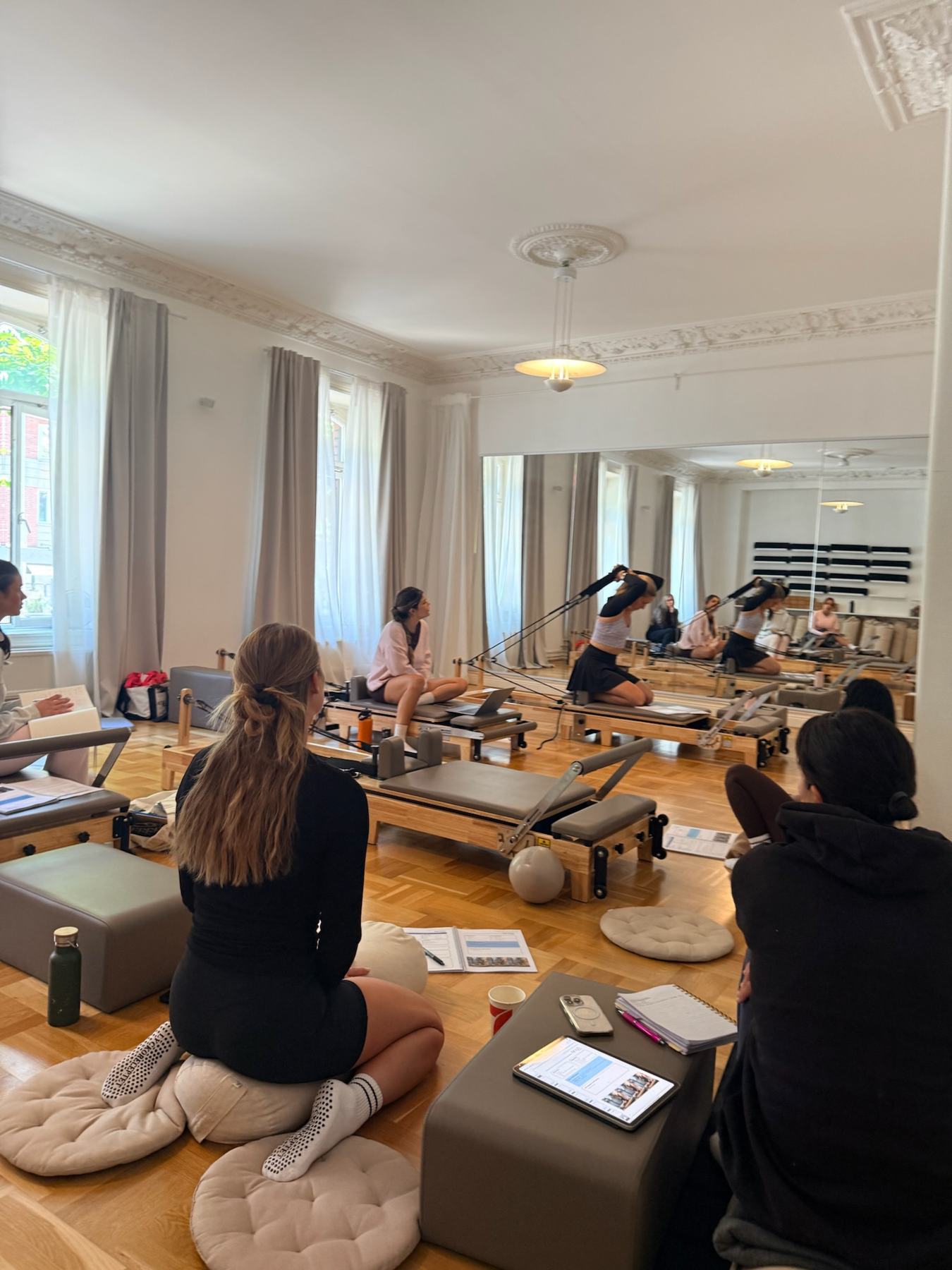 Instructor coaching a student on Pilates studio equipment at a Body Form Education intake